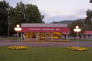 Shepherd Mountain Inn & Suites في Pilot Knob: مبنى به مصباحين على الشارع وسط العشب