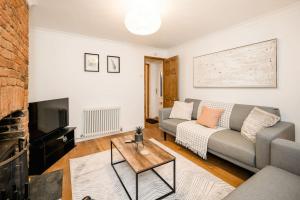 ein Wohnzimmer mit einem Sofa und einem Tisch in der Unterkunft 3 Bedroom home close to town centre with WiFi & garden in Royal Tunbridge Wells
