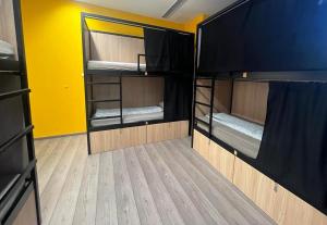 a room with two bunk beds and a yellow wall at Onefam Budapest in Budapest