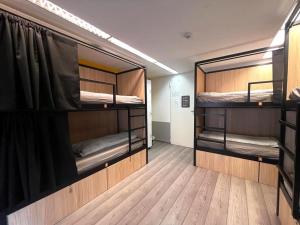 2 łóżka piętrowe w pokoju z drewnianą podłogą w obiekcie Onefam Budapest w Budapeszcie