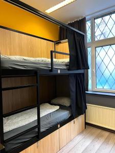 2 łóżka piętrowe w pokoju z oknem w obiekcie Onefam Budapest w Budapeszcie