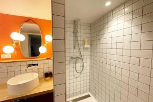 a bathroom with a shower and a white sink at Appartement Moonrise - Plage 50m - Rue gratuite in Saint Malo