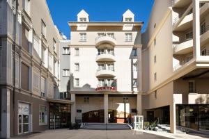 a large white building with a balcony at RockyPop Grenoble Appartements in Grenoble