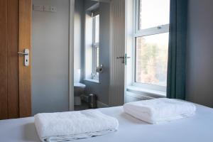 2 toallas en una cama en una habitación con ventana en Mid Wales Holiday Lets, Rhayader, en Rhayader