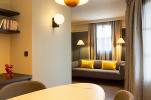 a living room with a couch and yellow pillows at RockyPop Grenoble Appartements in Grenoble