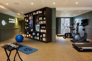 una habitación con un gimnasio con cinta de correr y equipo de ejercicios en RockyPop Grenoble Appartements en Grenoble