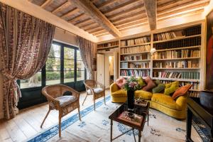 uma sala de estar com um sofá amarelo e estantes em Villa la Roseta em Ponte di Masino