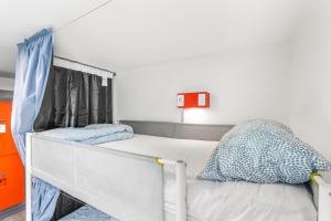 a small bedroom with a bunk bed with blue pillows at Samesun Toronto in Toronto