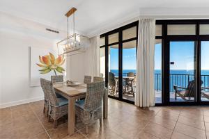 a dining room with a table and views of the ocean at Phoenix West 2005 in Orange Beach