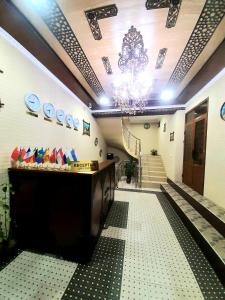 a lobby with a reception desk and stairs with a chandelier at Hotel Mohina in Samarkand
