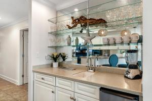 a kitchen with a sink and glass shelves at Phoenix West 2005 in Orange Beach +33 photos