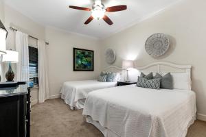 a bedroom with two beds and a ceiling fan at Phoenix West 2005 in Orange Beach