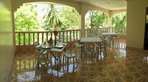 un restaurant avec des tables et des chaises sur un balcon dans l'établissement Lambug Beach Homestay, à Lambug