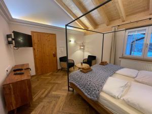 een slaapkamer met een groot bed en een tafel en stoelen bij Landhaus Kössel in Füssen