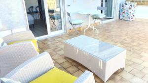 eine Terrasse mit Korbstühlen und einem Tisch auf der Terrasse in der Unterkunft Blue Sky Rooftop Apartments - Bari Policlinico in Bari