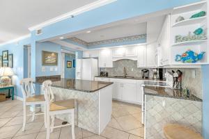a kitchen with white cabinets and a blue ceiling at SeaSpray West 603- Gulf Front in Perdido Key