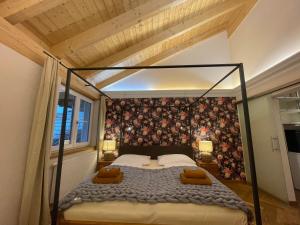 um quarto com uma cama de dossel num quarto em Landhaus Kössel em Füssen