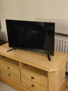 TV de pantalla plana en la parte superior de un soporte de madera en Ferienwohnung Grothoff, en Olsberg