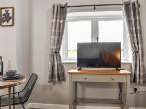 a desk with a laptop on it in front of a window at Sheepfold Cottage in Eccleshall