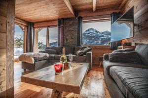 a living room with a couch and a table at Luxury chalet Léli in Saint-Chaffrey