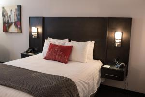 1 dormitorio con cama grande y almohada roja en Hotel des Eskers, en Amos