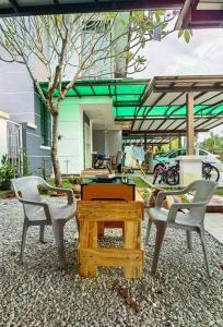 three chairs and a wooden table in front of a house at 18 Home team family Gathering first choice in Skudai +58 photos