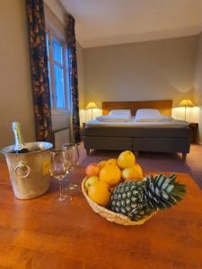 a table with a bowl of fruit and a bed at First Hotel Breiseth in Lillehammer