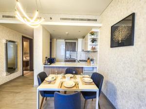 uma sala de jantar com uma mesa branca e cadeiras azuis em STAY BY LATINEM Luxury 1BR Holiday Home OPA 802 near Burj Khalifa em Dubai