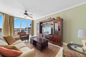 a living room with a couch and a tv at SeaSpray West 105- Gulf Front in Perdido Key