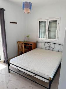 een bed in een kamer met een tafel en een raam bij Two-floor fully equipped maisonette in the nature 