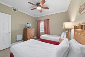 a bedroom with two beds and a ceiling fan at SeaSpray West 105- Gulf Front in Perdido Key +30 photos