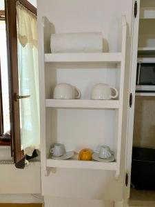 un armario con vajilla, tetera y toallas en Romantic Suite, en Gubbio