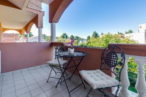 a patio with two chairs and a table on a balcony at Hotel Marinko in Zadar