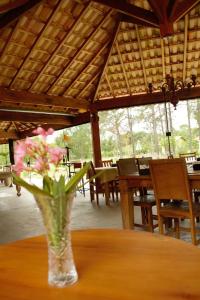 a vase with pink flowers sitting on a table at Aconchego da bocaina in Cunha