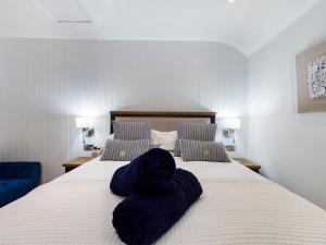 a bedroom with a bed with blue towels on it at Driftwood Boutique Guest House in Rhosneigr
