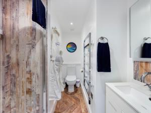 a bathroom with a toilet and a sink at Driftwood Boutique Guest House in Rhosneigr