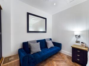 a blue couch in a living room with a mirror at Driftwood Boutique Guest House in Rhosneigr