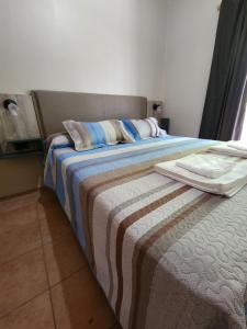 1 dormitorio con 1 cama con manta a rayas en Alma Malbec en San Rafael