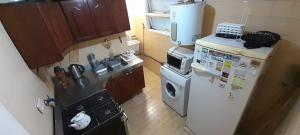 a small kitchen with a refrigerator and a microwave at Departamento Malvinas in Corrientes +3 photos