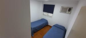 a small bedroom with a blue bed and a window at Departamento Malvinas in Corrientes