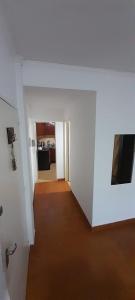 a room with a white wall and a hallway at Departamento Malvinas in Corrientes