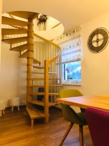 - un escalier en colimaçon dans une salle à manger avec une table et une horloge dans l'établissement Bio Schartenhof, à Sankt Johann im Pongau