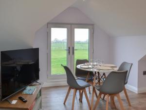 a dining room with a table and chairs and a television at Hanoverian Suite - Uk41830 in Tickton