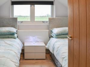 a bedroom with two twin beds and a window at Hanoverian Suite - Uk41830 in Tickton