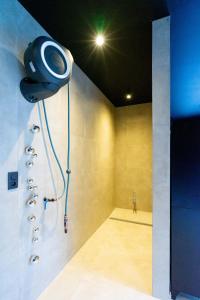 a bathroom with a shower with a light on the wall at Ardn-bnb Bike n Bed in La-Roche-en-Ardenne