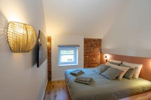 a bedroom with a large bed with a brick wall at Ardn-bnb Bike n Bed in La Roche-en-Ardenne