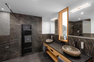 ein Badezimmer mit 2 Waschbecken und einem Spiegel in der Unterkunft Hotel Bergflair in Fischen im Allgäu