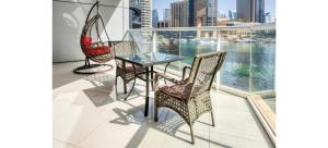 a balcony with a glass table and two chairs at Luxurious 4-Bedroom Duplex VILLA Apartment near JBR in Dubai