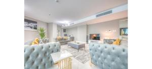 a living room with blue chairs and a couch at Luxurious 4-Bedroom Duplex VILLA Apartment near JBR in Dubai