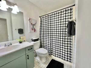 a bathroom with a toilet and a black and white shower at Black Bear Lodge in Basye